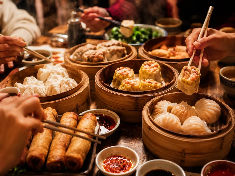 Des paniers de dim sum et de nems fumants, les baguettes qui plongent